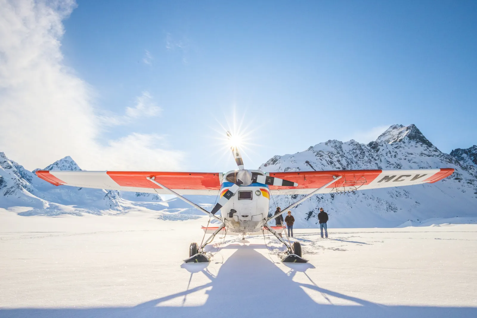 Ski plane parked head-on on the Tasman Glacier snowfield in bright sun