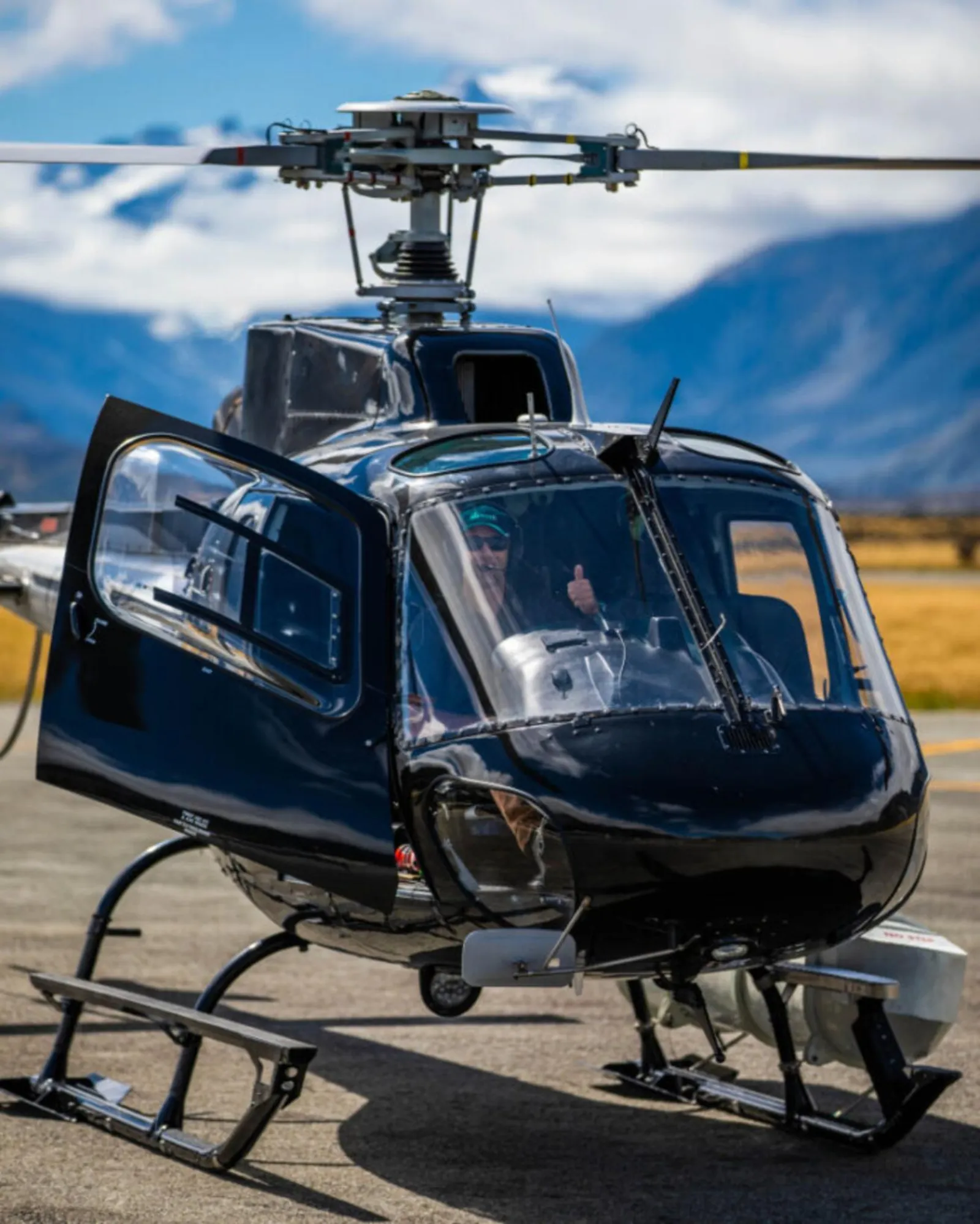 Black INFLITE helicopter with its doors open, ready for boarding