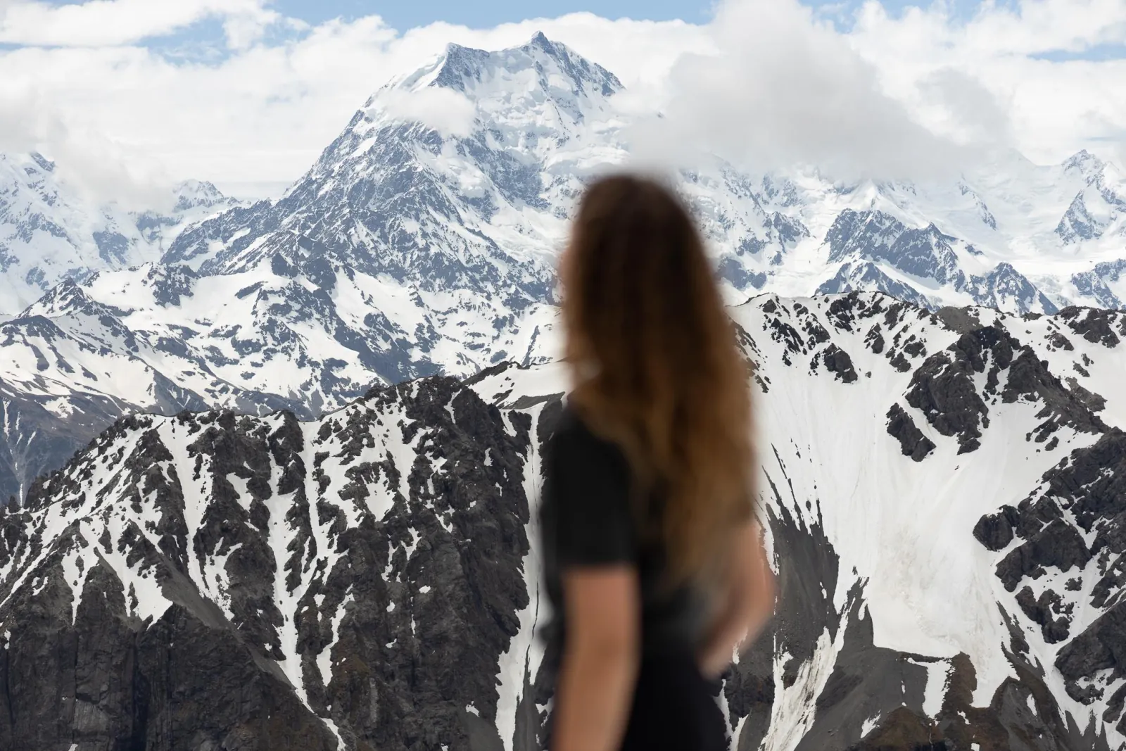 Passenger looking out at the snow-covered peaks of the Southern Alps
