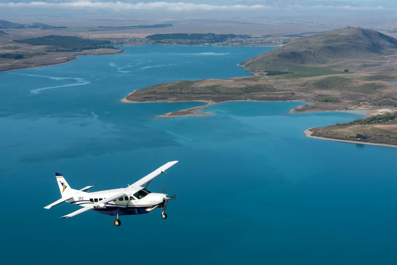 Air Safaris plane flying over the turquoise water of Lake Tekapo