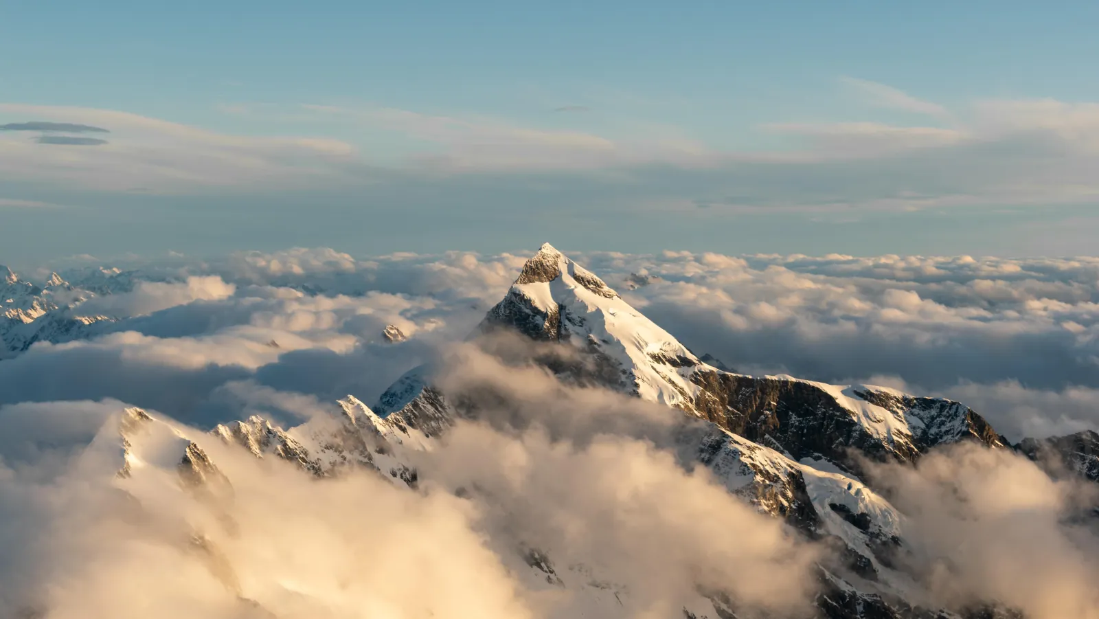 Aoraki/Mount Cook rising above a sea of cloud in golden light