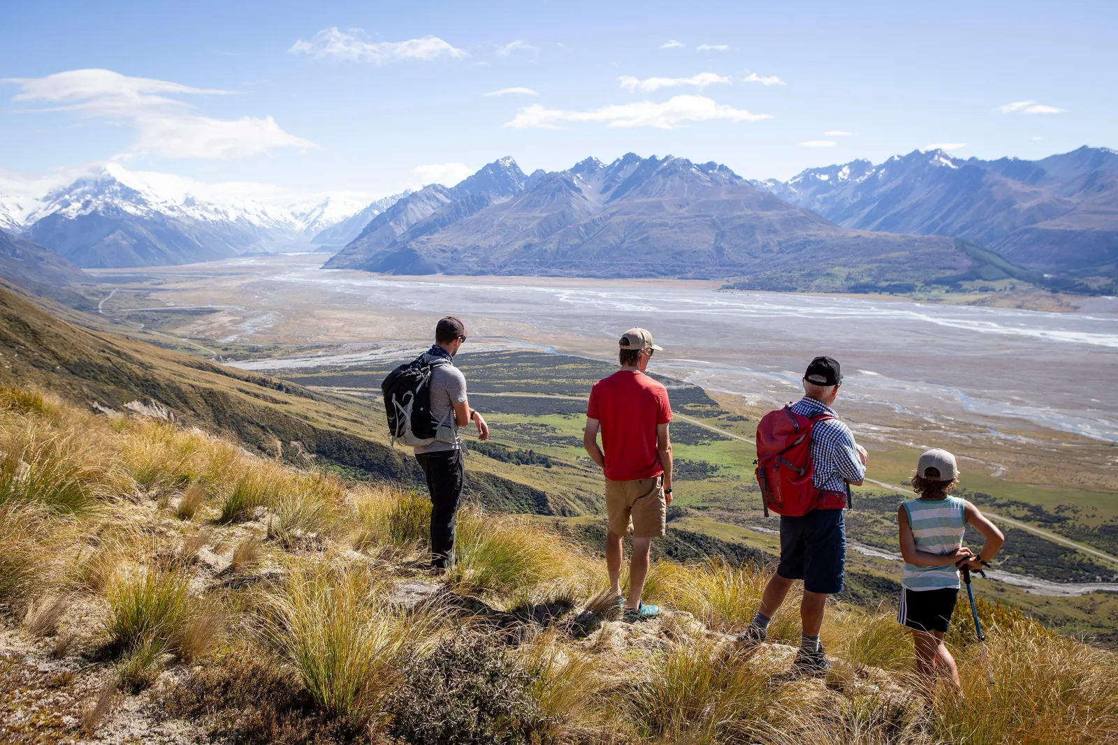 Hikers looking down the Tasman River valley from a tussock ridge