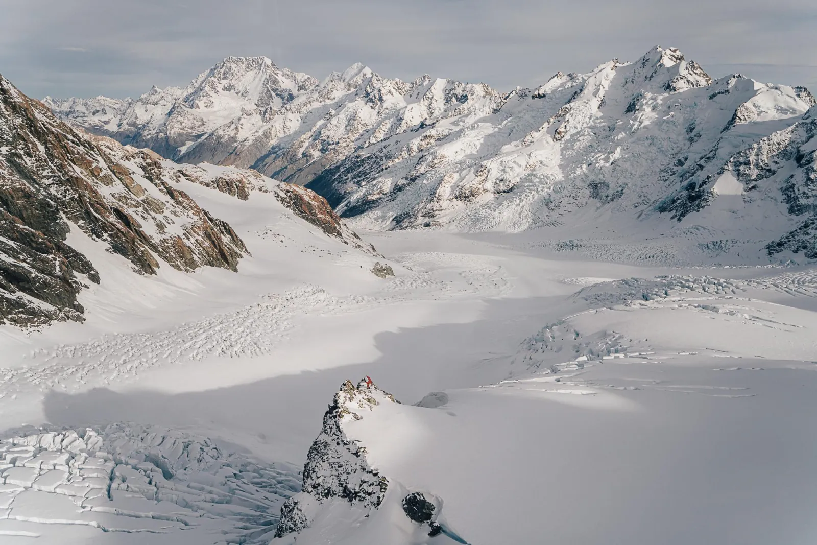 Aerial view of a broad glacier névé flanked by snowy peaks