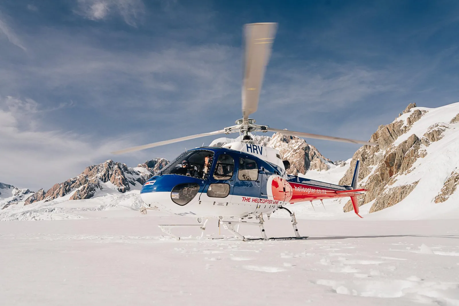 The Helicopter Line helicopter with rotors turning on a snowfield